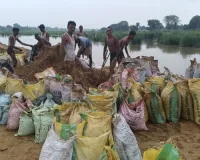 झांपदा में ग्रामीणों द्वारा तैयार किए गए कच्चे बांध की कट्टों में मिट्टी डालकर ग्रामीण कर रहे मजबूती 