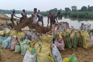 झांपदा में ग्रामीणों द्वारा तैयार किए गए कच्चे बांध की कट्टों में मिट्टी डालकर ग्रामीण कर रहे मजबूती 