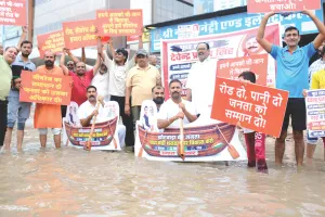निवारू रोड पर पानी में खड़े होकर दिया धरना : सड़क पर भरा पानी, सांकेतिक नाव चलाकर किया प्रदर्शन 