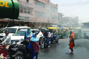 भीषण गर्मी में निगम द्वारा सड़क पर पानी का छिड़काव